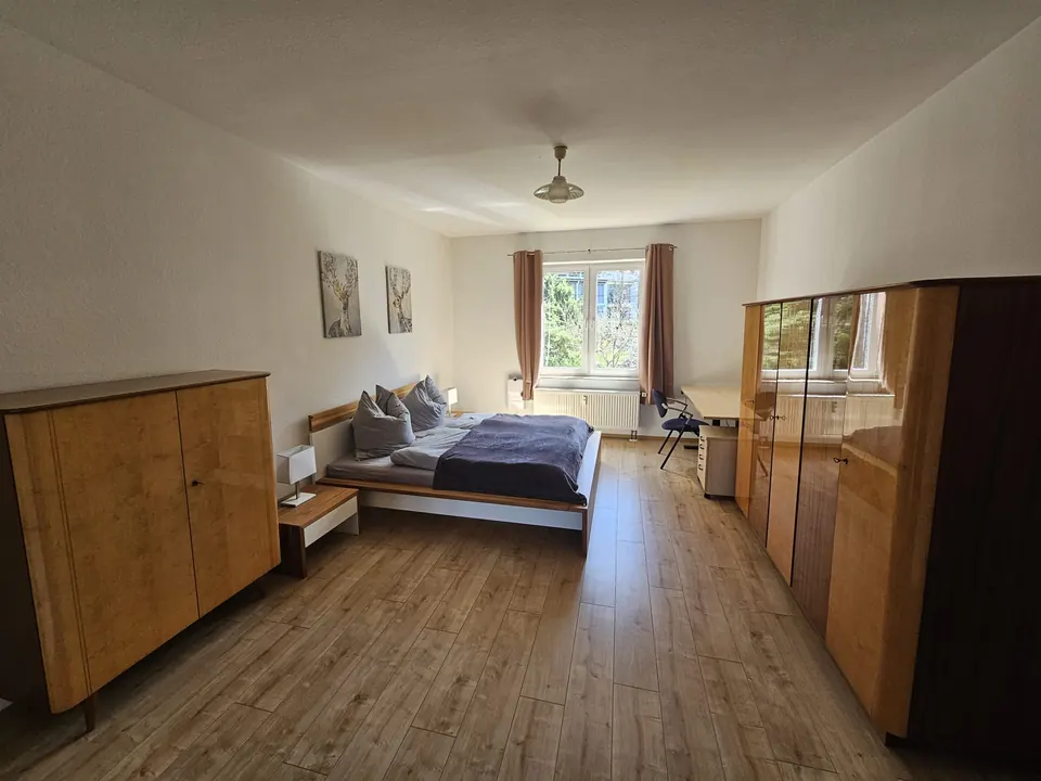 Hauptschlafzimmer mit Fenster zum Grünen und Arbeitsplatz